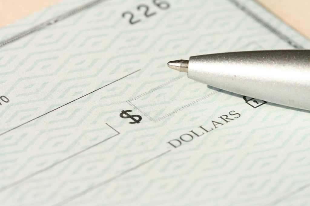 A bank cheque with a pen, illustrating UAE cheque law and the 2022 decriminalization reform