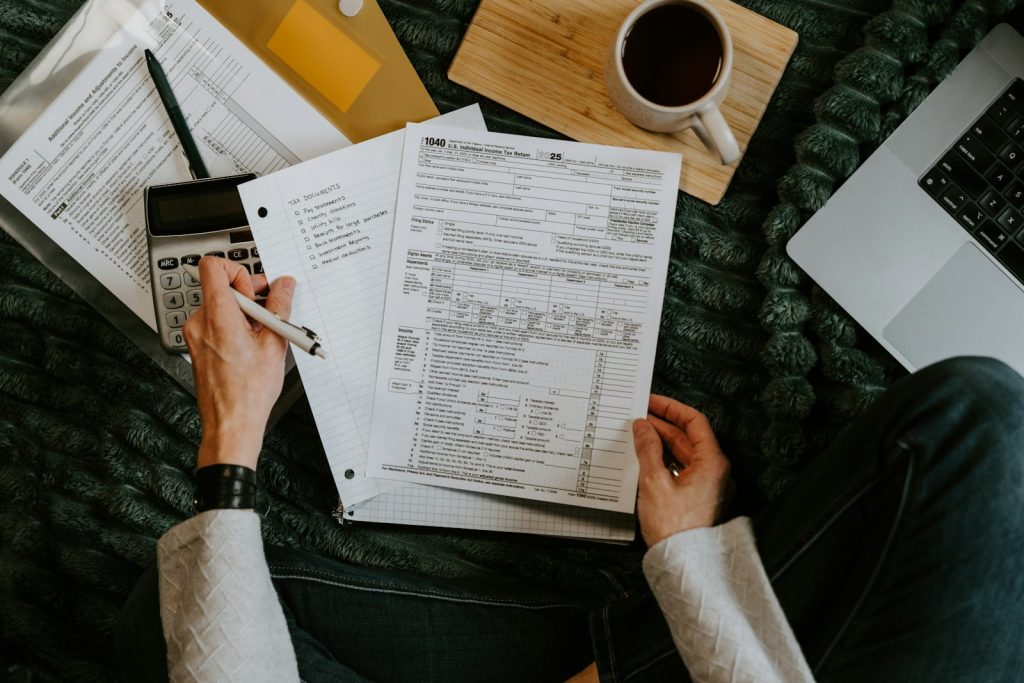 Reviewing documents with a calculator and laptop, illustrating Australian tax residency and HELP debt obligations from the UAE